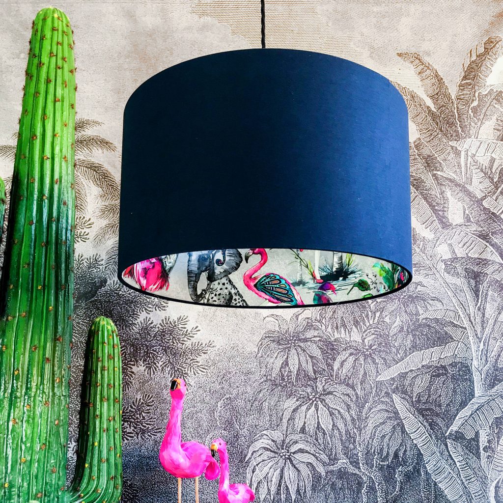 Eccentric hanging lampshade with vibrant elephant flamingo print against tropical wallpaper