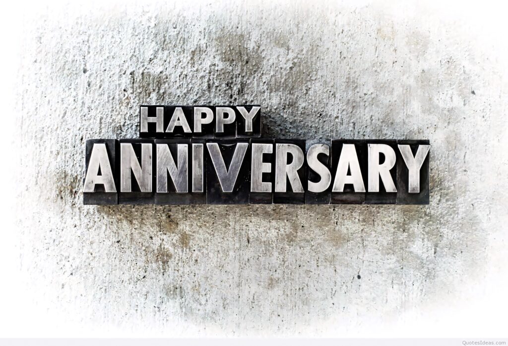 Bold metallic Happy Anniversary letters on textured concrete background modern celebration wallpaper