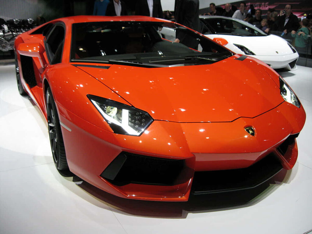 Orange Lamborghini GT4 with aggressive design and sharp lines showcased under bright lights Wallpaper