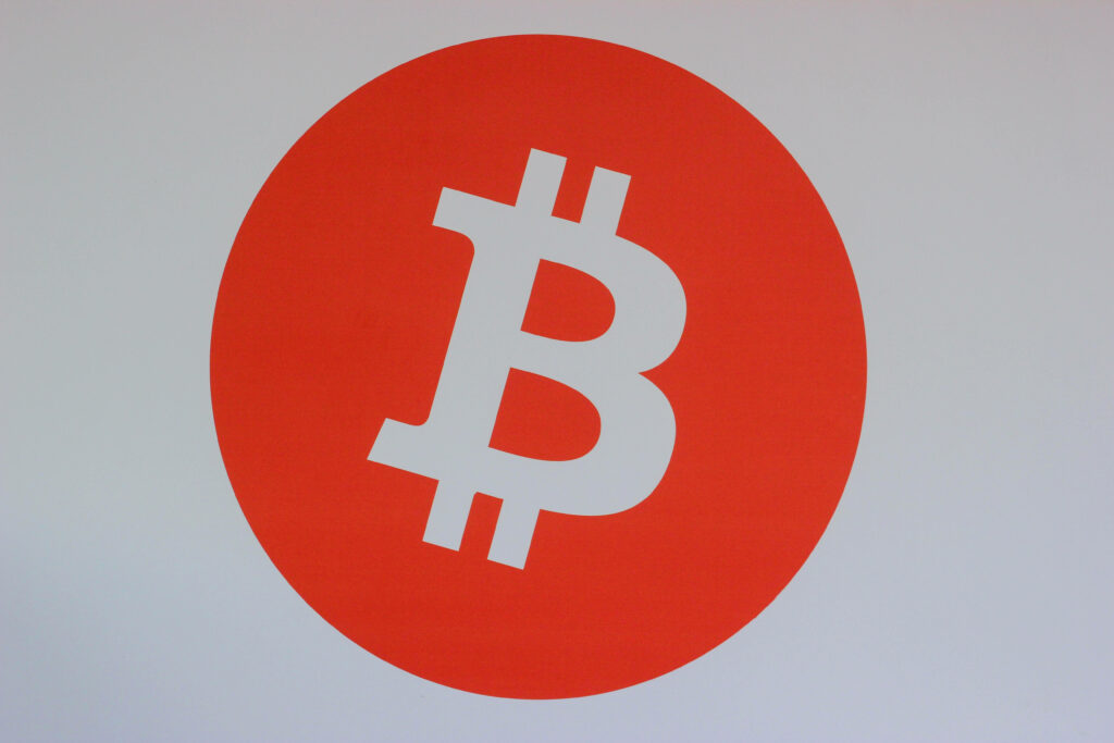 Bold red circle with white Bitcoin symbol representing crypto investing and financial optimism wallpaper