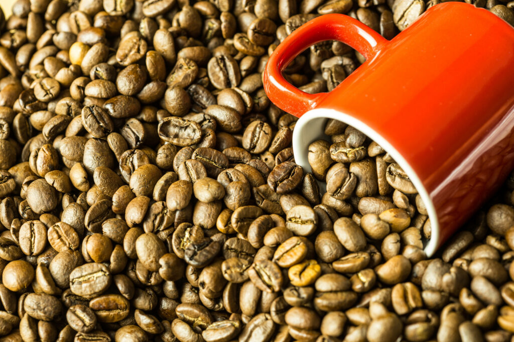 Large red coffee mug on rich coffee beans background coffee-themed wallpaper image
