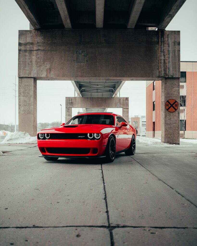 Red Dodge Challenger SRT: Bold Design Against Urban Background Wallpaper