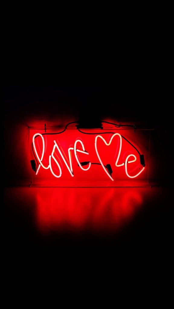 Glowing red neon love Me sign on black background minimalist romantic aesthetic wallpaper