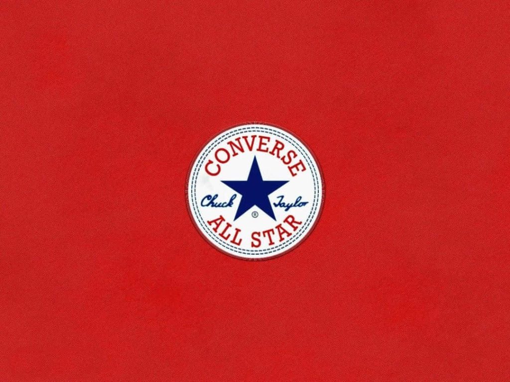 Minimalist wallpaper red background with white blue Converse Chuck Taylor All Star patch centered