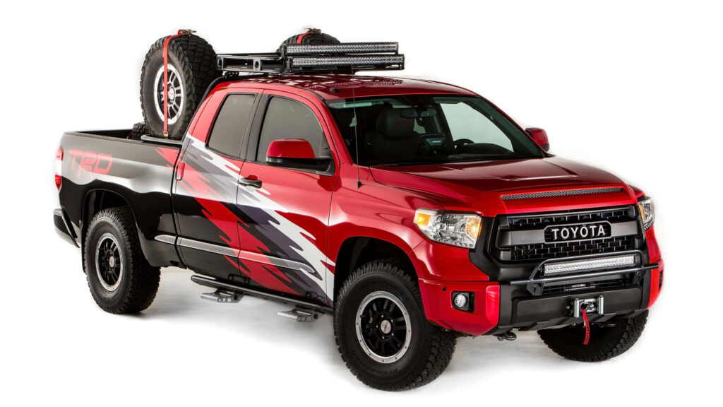 Red Toyota TRD Tundra with off-road tires aggressive graphics and roof rack lighting wallpaper