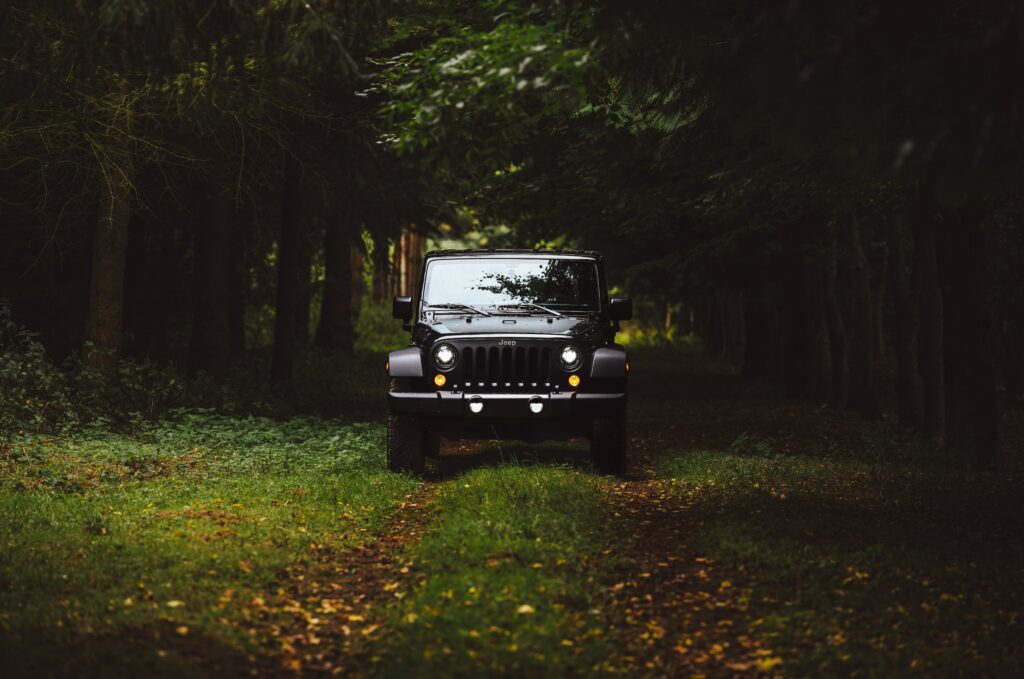 Rugged SUV Wallpaper Surrounded by Lush Greenery and Foliage
