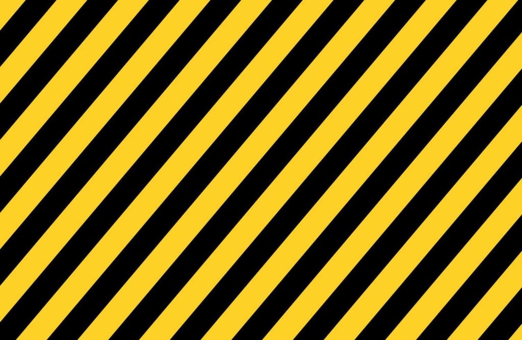 Yellow and black diagonal striped wallpaper with bold industrial hazard-inspired design background
