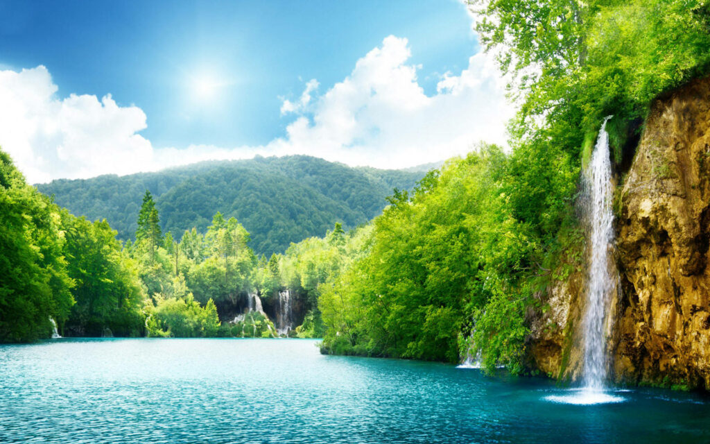 Serene vistas: An HD Blue Lagoon Wallpaper with lush greenery in the background