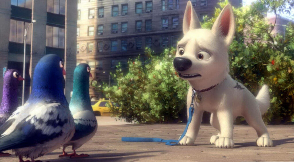 Bolt the dog interacts with colorful pigeons on urban sidewalk with buildings and greenery Wallpaper