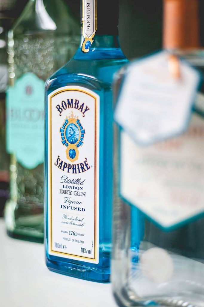 Elegant Bombay Sapphire London Dry Gin bottle vibrant blue glass soft blurred background Wallpaper