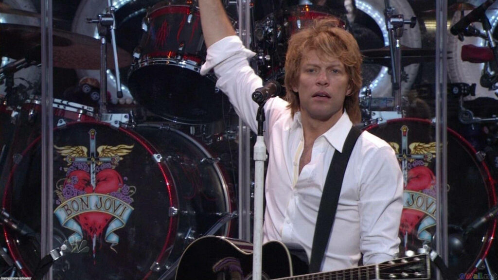 Bon Jovi passionately performing live at Giants Stadium Live Earth 2007 with heart dagger logo Wallpaper