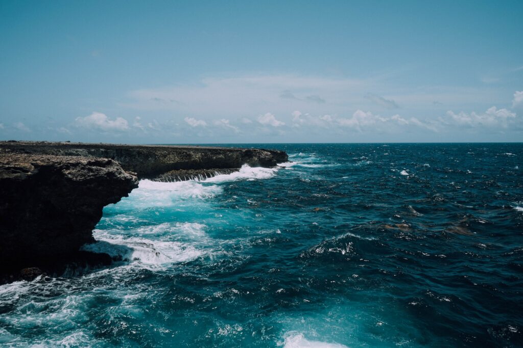 Rugged Bonaire coastline with vibrant blue water crashing surf and clear Caribbean sky wallpaper