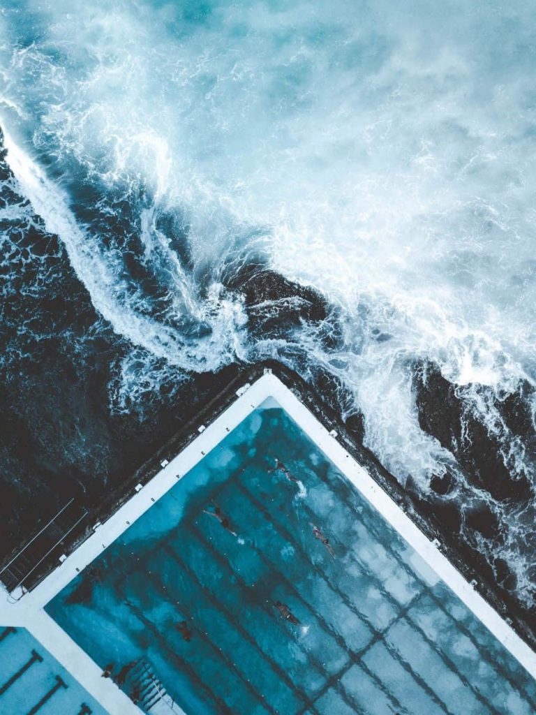 Aerial view of Bondi Icebergs Pool with turquoise water and crashing ocean waves wallpaper