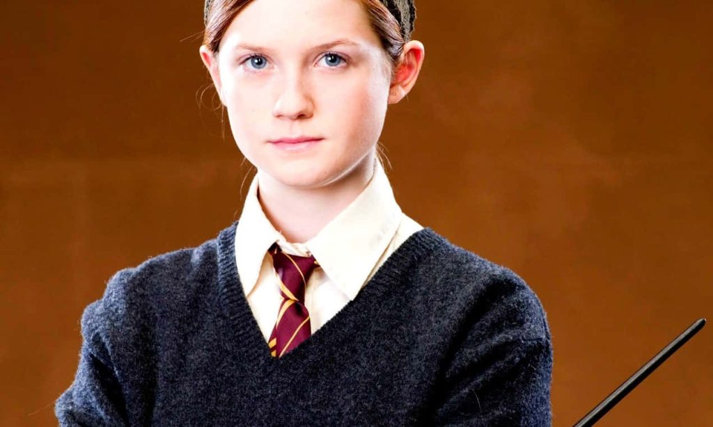 Portrait of Bonnie Wright as young Ginny Weasley in Hogwarts uniform holding wand wallpaper
