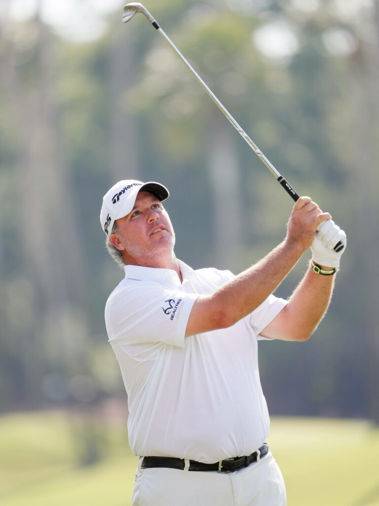 Boo Weekley focused golf swing on lush green course golf wallpaper background for sports fans