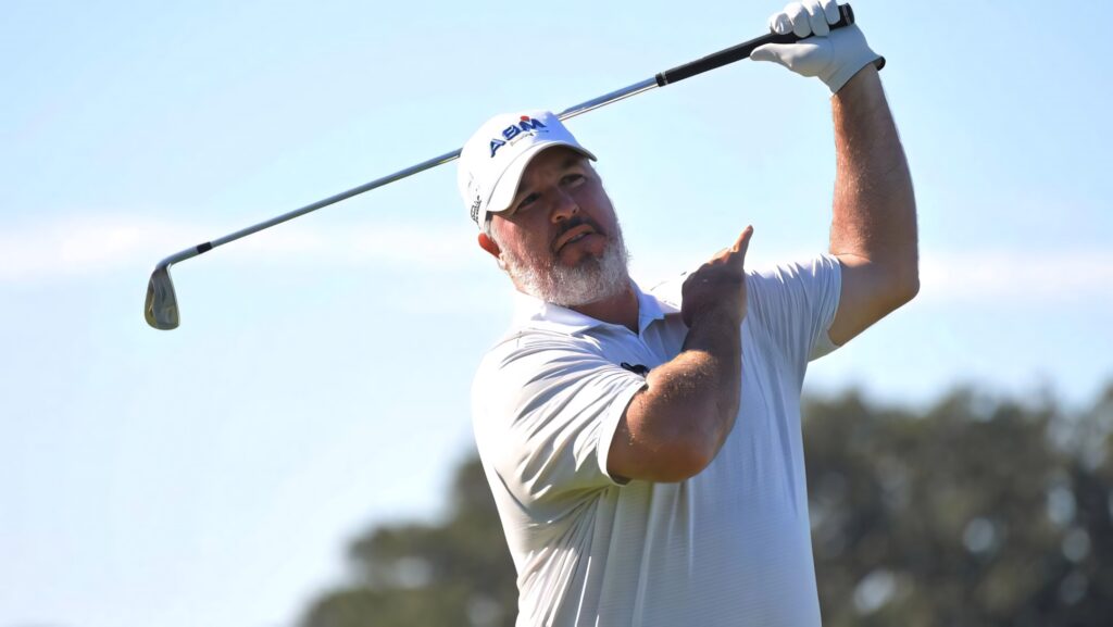 Boo Weekley mid-swing golf wallpaper bright blue sky focused golfer athletic form background