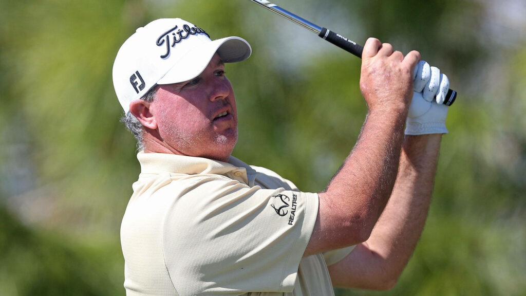 Boo Weekley mid-swing golf wallpaper with beige Titleist cap natural light blurred greens background