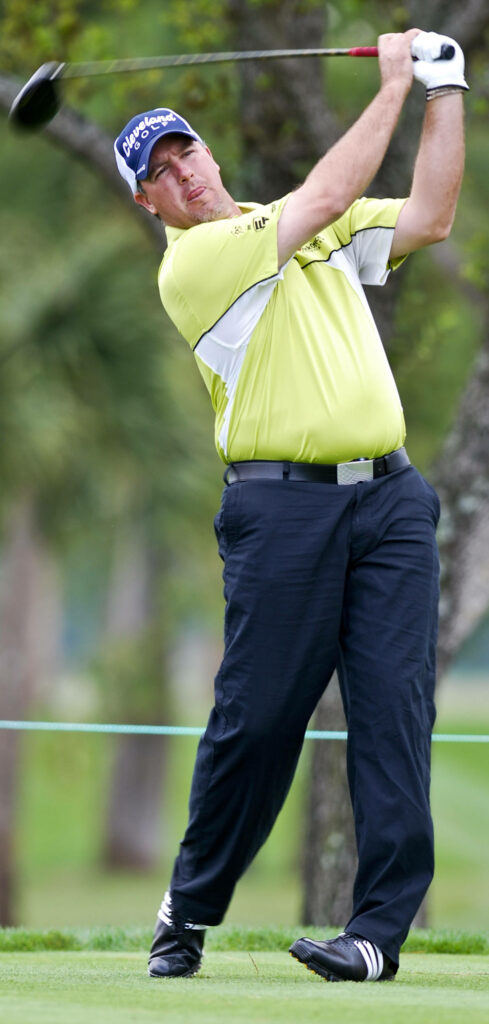 Boo Weekley mid-swing golf wallpaper yellow shirt navy pants lush green course background