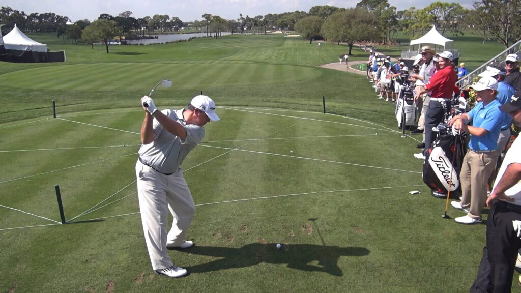 Boo Weekley powerful golf backswing on lush course with spectators dynamic sports wallpaper
