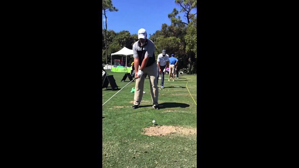 Professional golfer Boo Weekley poised for swing on sunny lush driving range wallpaper background