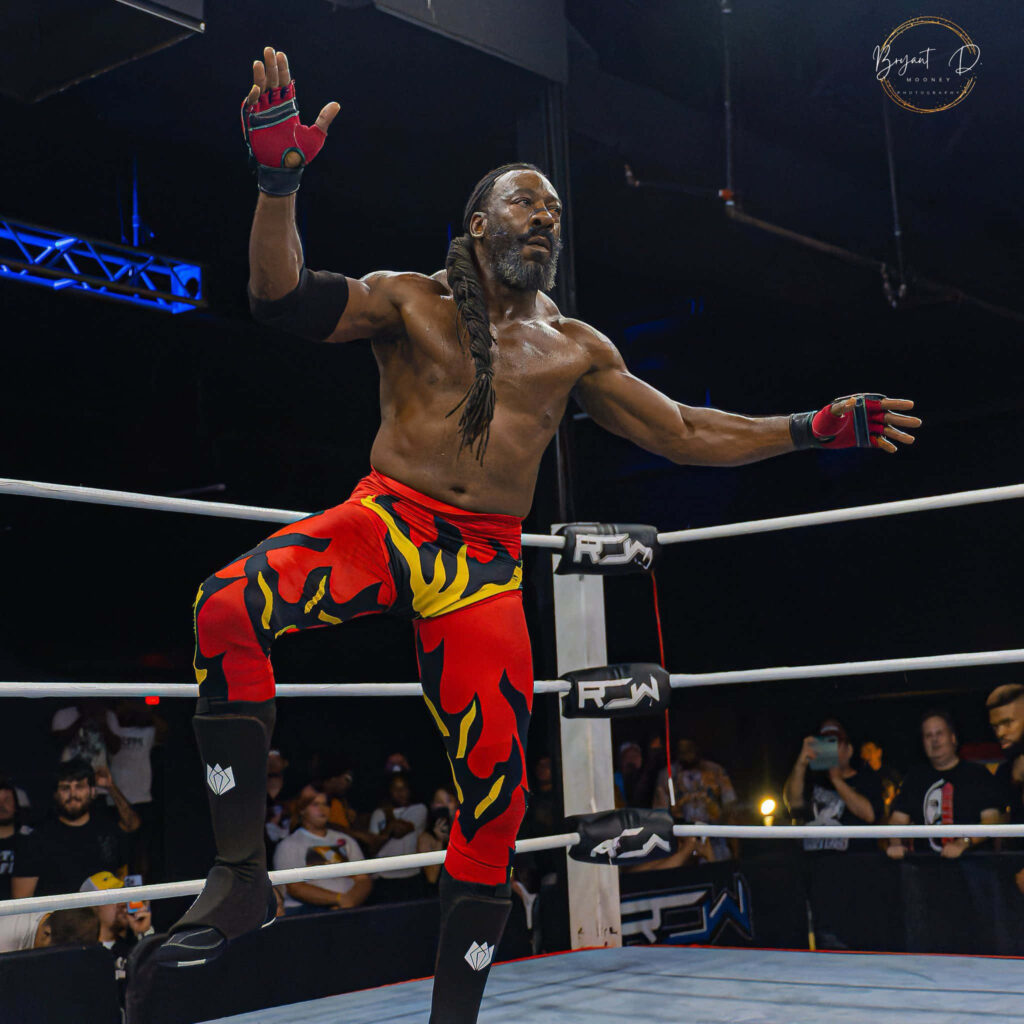 Booker T WWE wrestler powerful pose muscular physique flame pants cheering crowd arena lighting Wallpaper