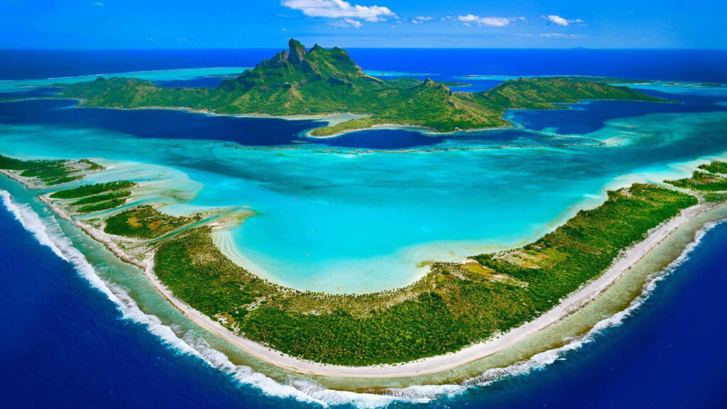 Aerial view of Bora Bora with turquoise waters lush islands and volcanic mountain tropical paradise Wallpaper