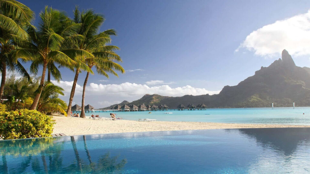 Bora Bora wallpaper featuring pool palm trees white sandy beach turquoise water bungalows mountains
