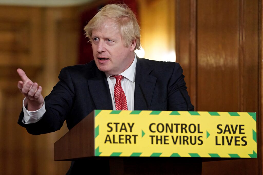 Boris Johnson giving COVID-19 speech at podium with Stay Alert Control Virus Save Lives sign background Wallpaper