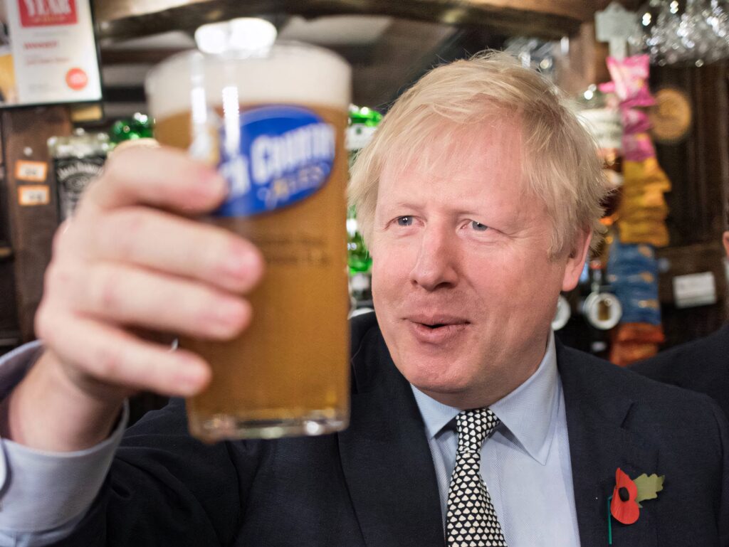 Boris Johnson raising a pint of beer in a lively pub with warm lighting and vibrant details wallpaper