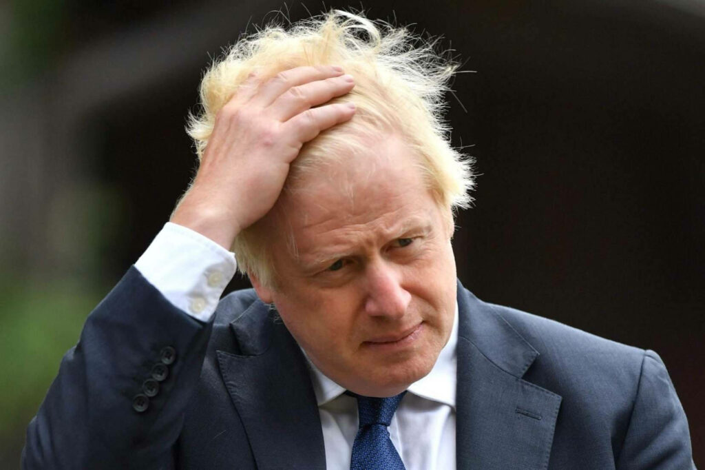 Boris Johnson fixing hair outdoors navy suit blue tie candid political portrait natural light Wallpaper