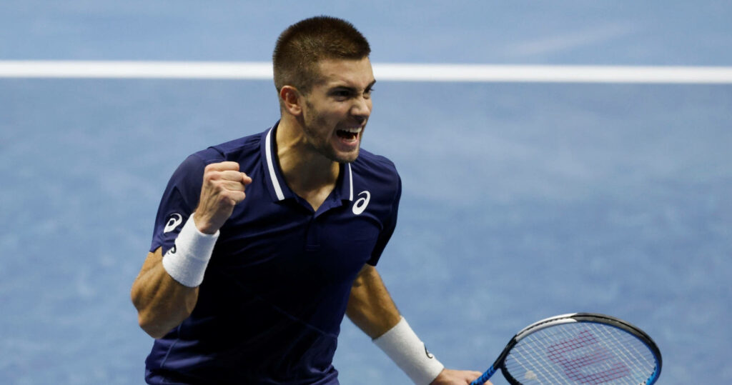 Borna Coric fist pump on blue hard court showing intense energy and tennis action wallpaper