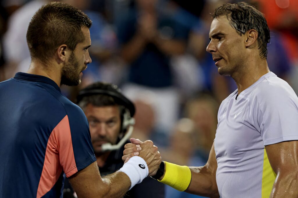 Borna Coric and Rafael Nadal handshake tennis sportsmanship vibrant crowd wallpaper background