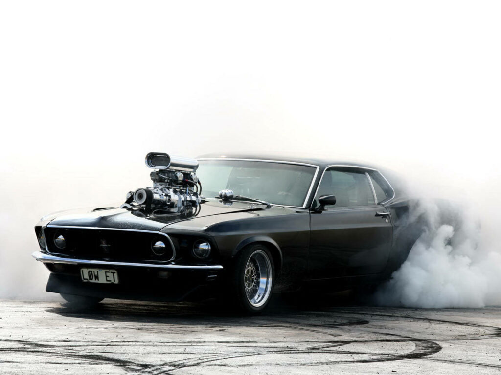Boss 302 Mustang muscle car performing smoky tire burnout showcasing raw power and style Wallpaper