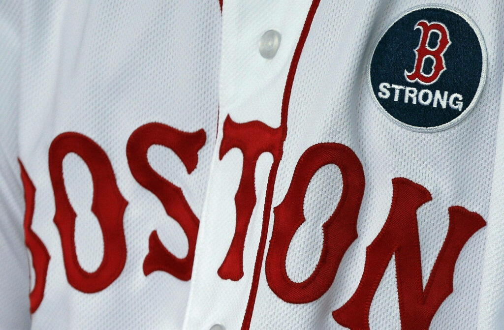 Close-up of Boston Red Sox uniform with bold red lettering and B Strong patch wallpaper background