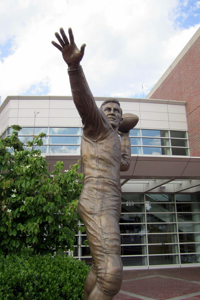Bronze Harry Agganis statue at Boston University Agganis Arena with greenery and sky wallpaper