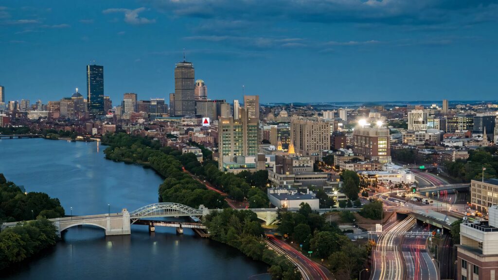 Evening Boston University Bridge over Charles River with city lights greenery and light trails wallpaper