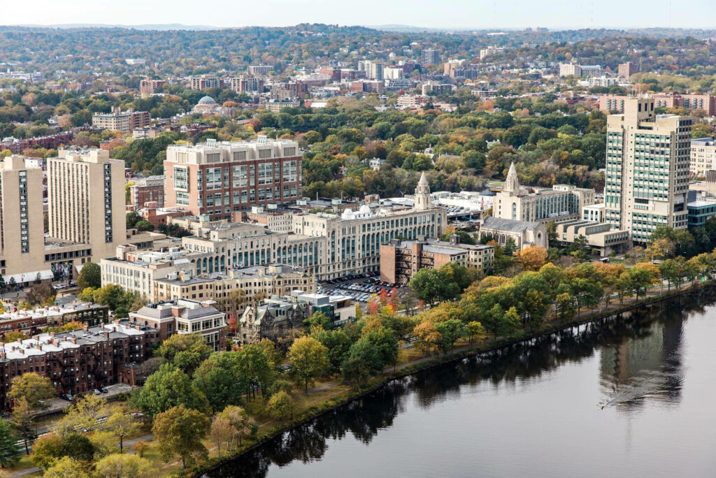 Aerial view of Boston University campus with iconic buildings fall foliage and Charles River background Wallpaper