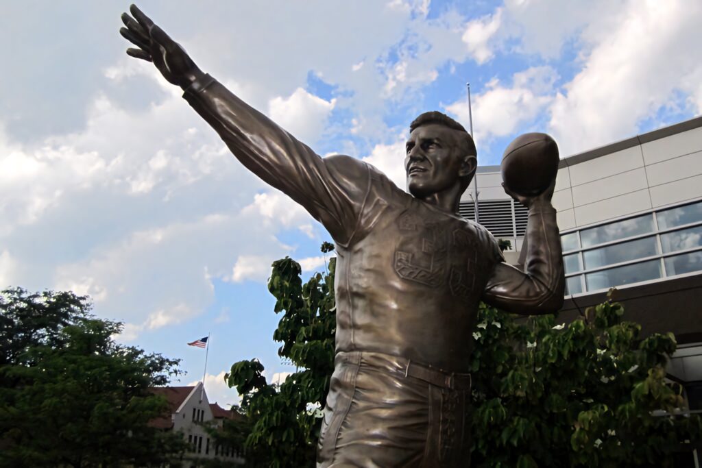Boston University Harry Agganis bronze statue throwing pose campus greenery blue sky wallpaper