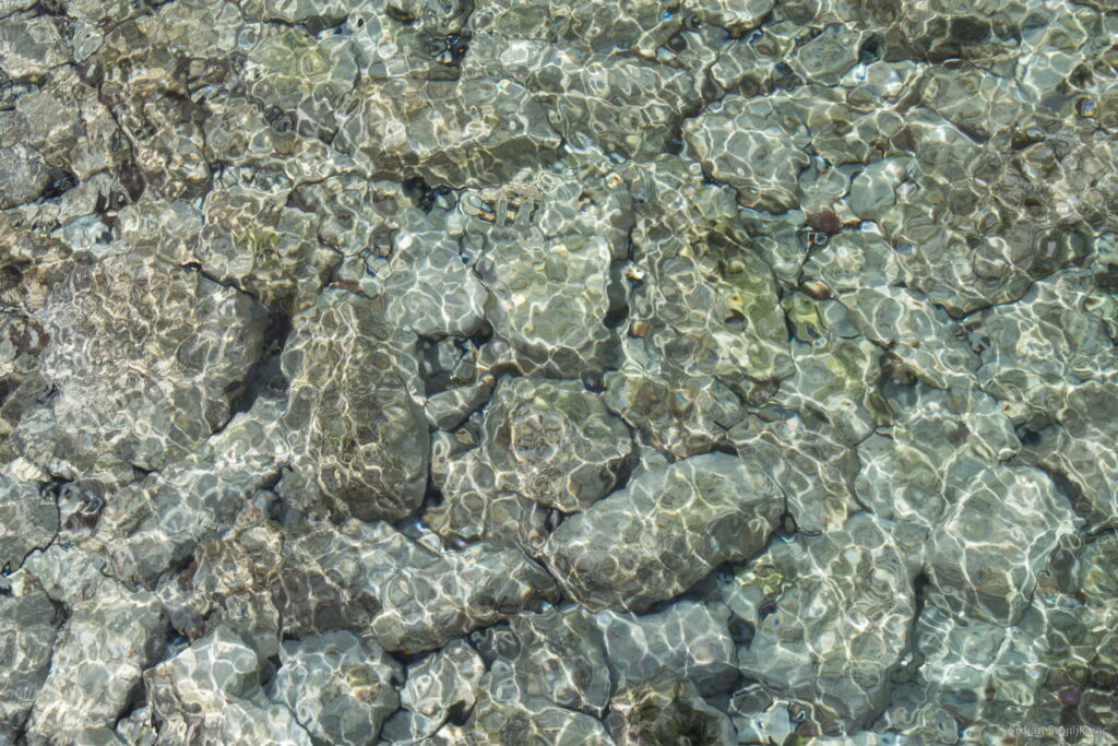 Crystal Clear Reflection: Stunning HD Wallpaper with Water Glare and Transparent Stones