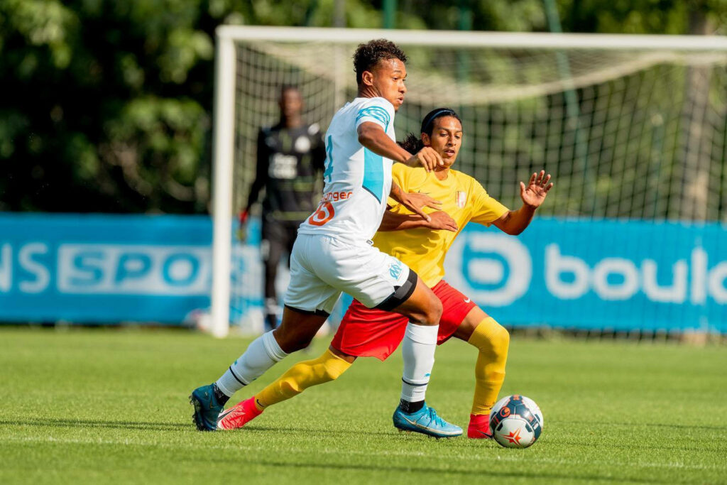 Boubacar Kamara dynamic midfielder dribbling ball on vibrant green pitch in white light blue kit Wallpaper