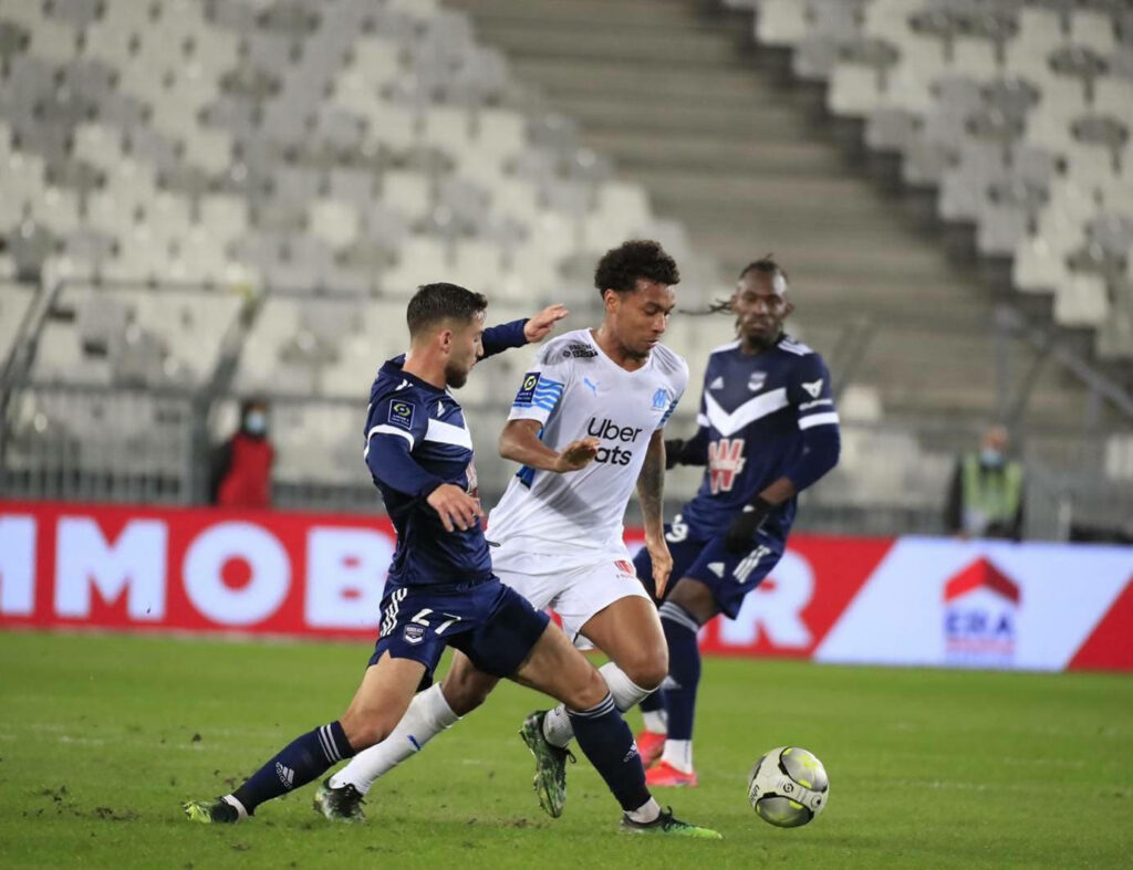Boubacar Kamara Olympique de Marseille defending action on green pitch intense football match background Wallpaper