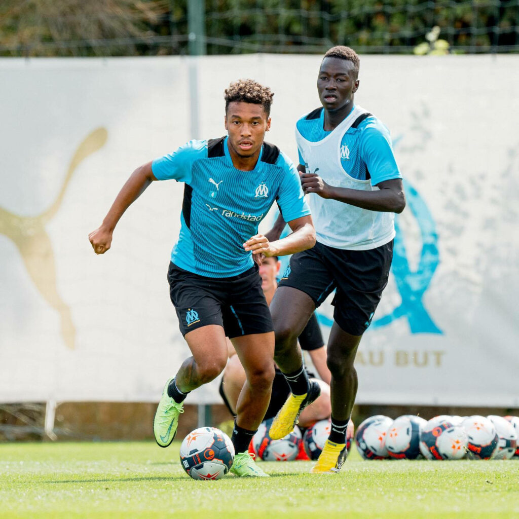 Boubacar Kamara running in Olympique de Marseille blue kit during outdoor football training session Wallpaper