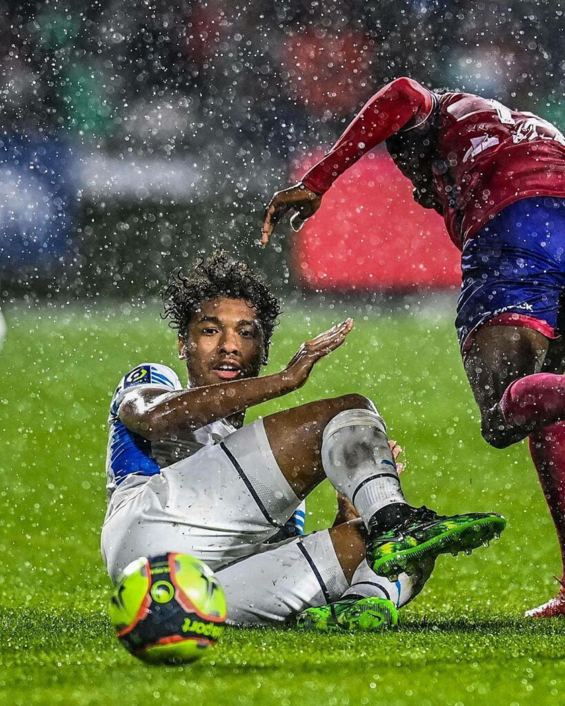 Boubacar Kamara sliding on rain-soaked football pitch showing intense action and determination Wallpaper