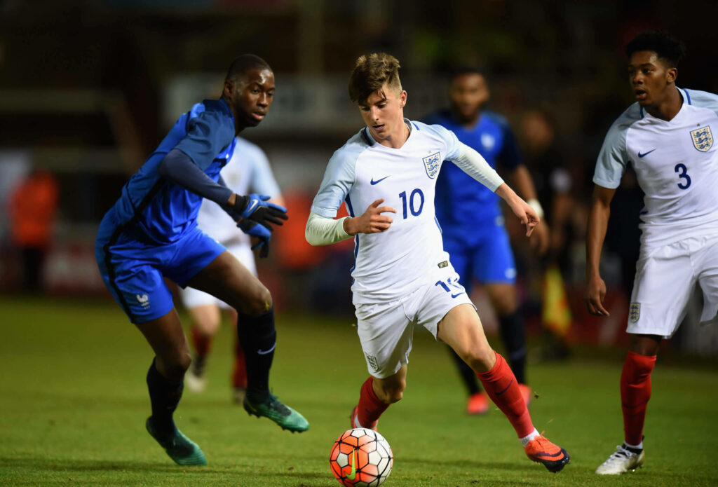 Boubakary Soumaré in dynamic international football match with blue white kits on green pitch Wallpaper