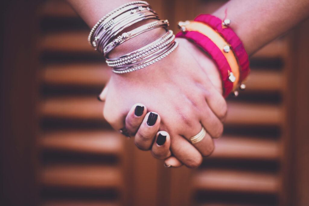 Friendship Bonds Captured: A Heartwarming Closeup of Bracelet-Adorned Hands Wallpaper