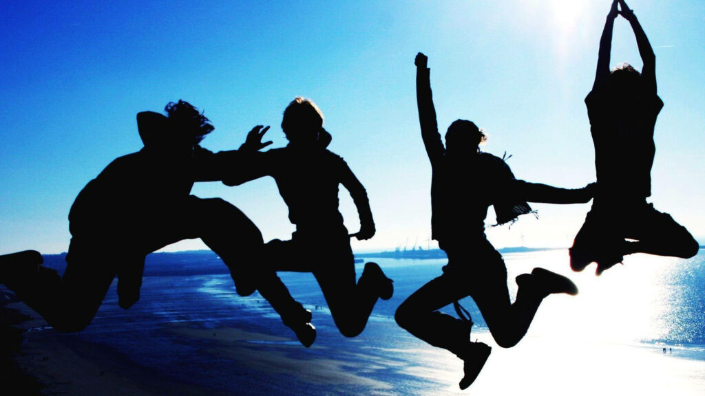 Boundless Joy: Lifelong Friendships Soaring by the Seaside Wallpaper