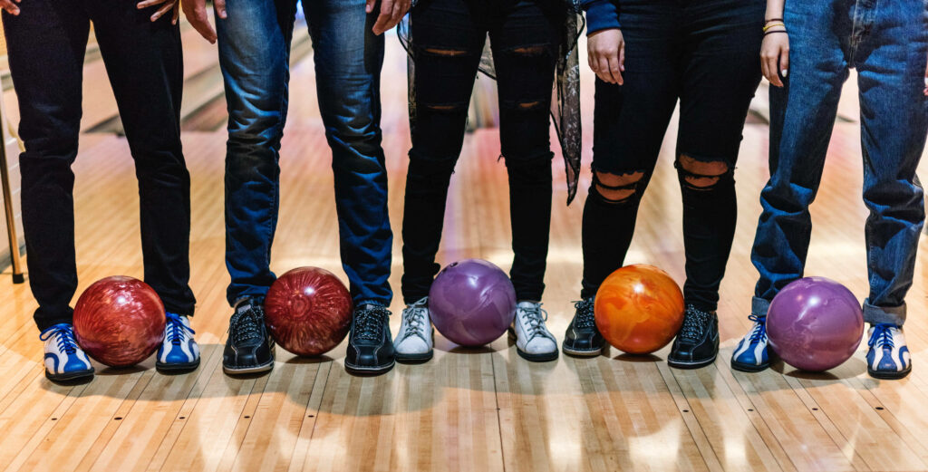 Friends enjoying bowling night colorful balls polished wooden lane vibrant alley wallpaper background