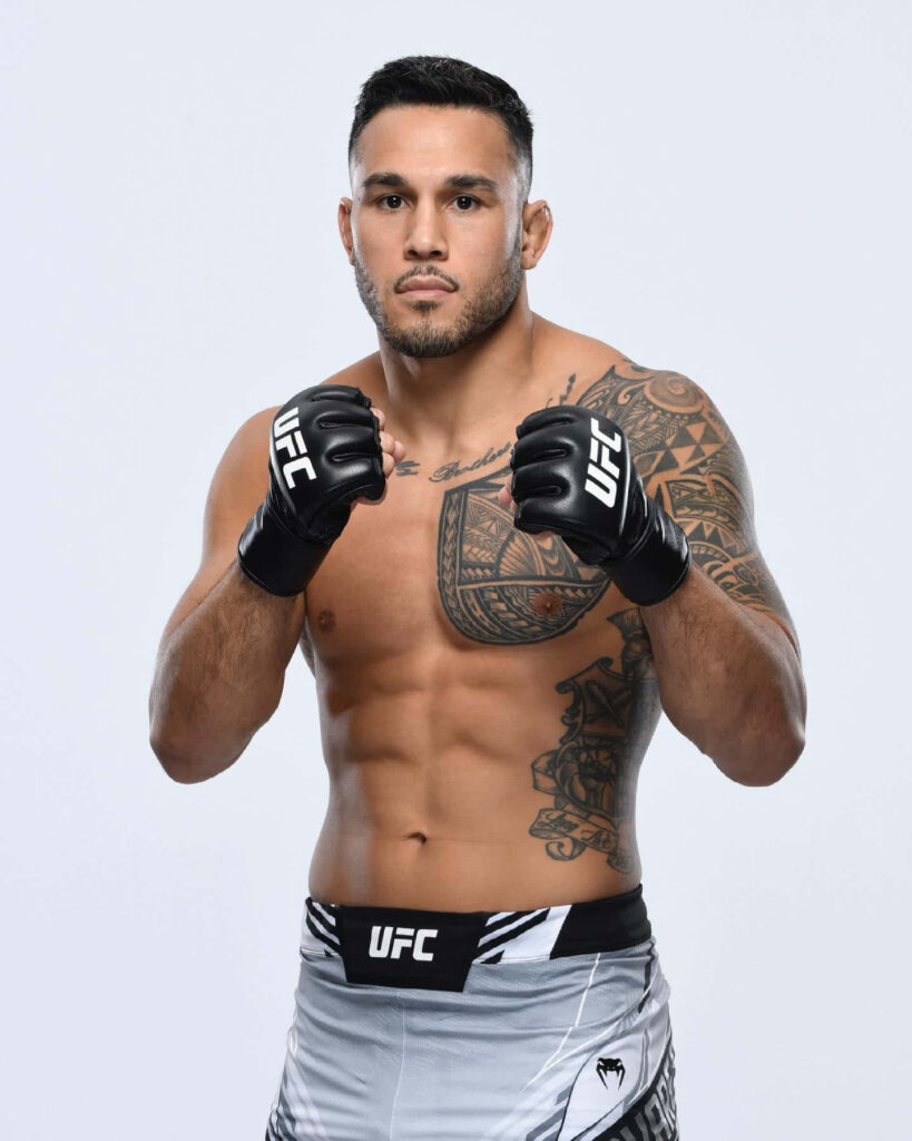 UFC fighter Brad Tavares in official gear showcasing athletic build and tattoos on white background Wallpaper