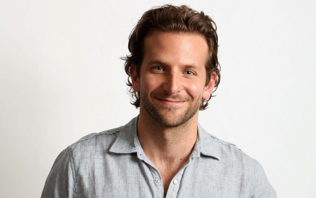 Bradley Cooper smiling warmly in bright relaxed wallpaper with light simple background