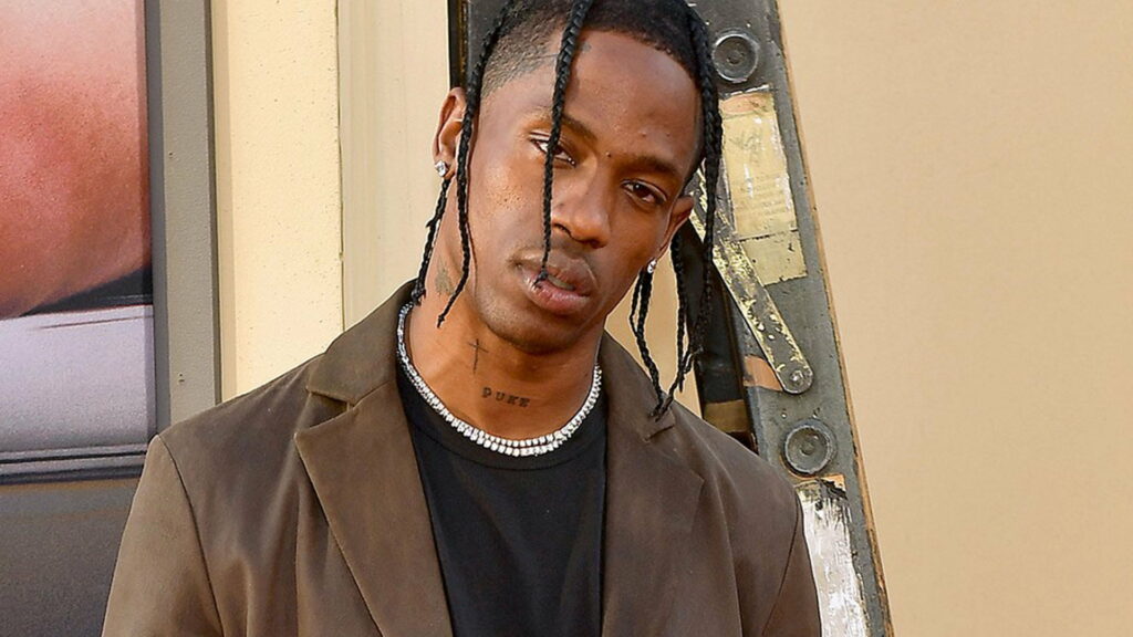 Travis Scott's Braided Mane Unveils Edgy Style in Black Tee and Brown Overcoat Wallpaper